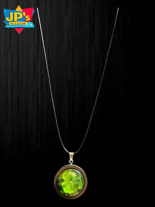 Four leaf clover pendant necklace with green resin stone set in wooden frame on black cord chain.