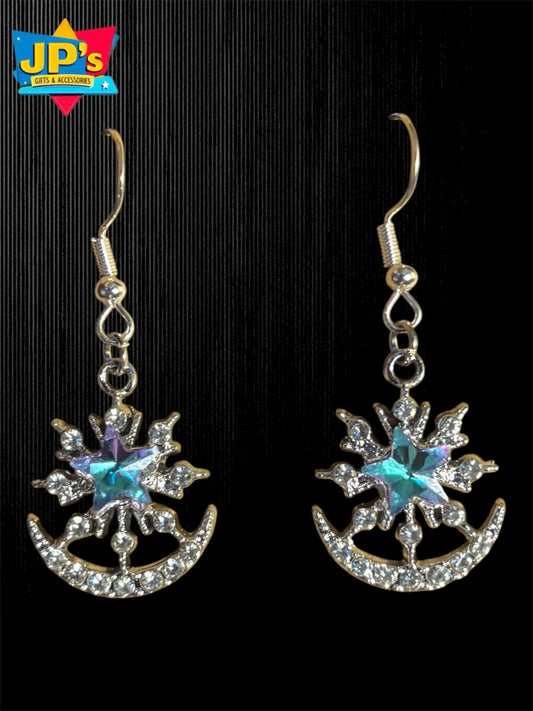 Pair of silver plated star and crescent moon earrings with turquoise center stones and rhinestone details on hooks.