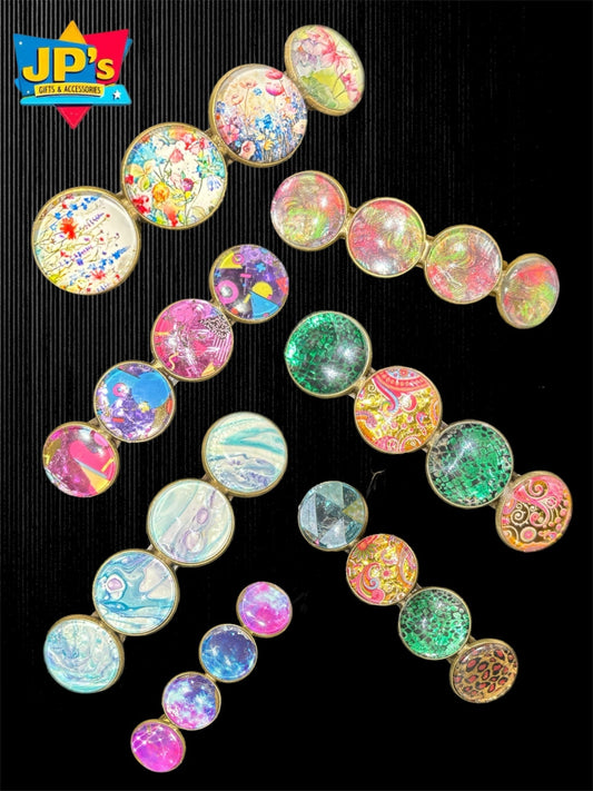 Collection of 24 large patterned hair clips featuring colorful designs including florals, galaxies, and abstract patterns on black background.