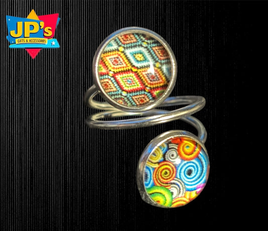 Silver spiral double ring with two colorful geometric patterned resin domes featuring boho designs.