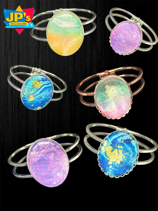 Six metal cabochon bracelets with colorful artistic designs including starry night, watercolor, and earth patterns.